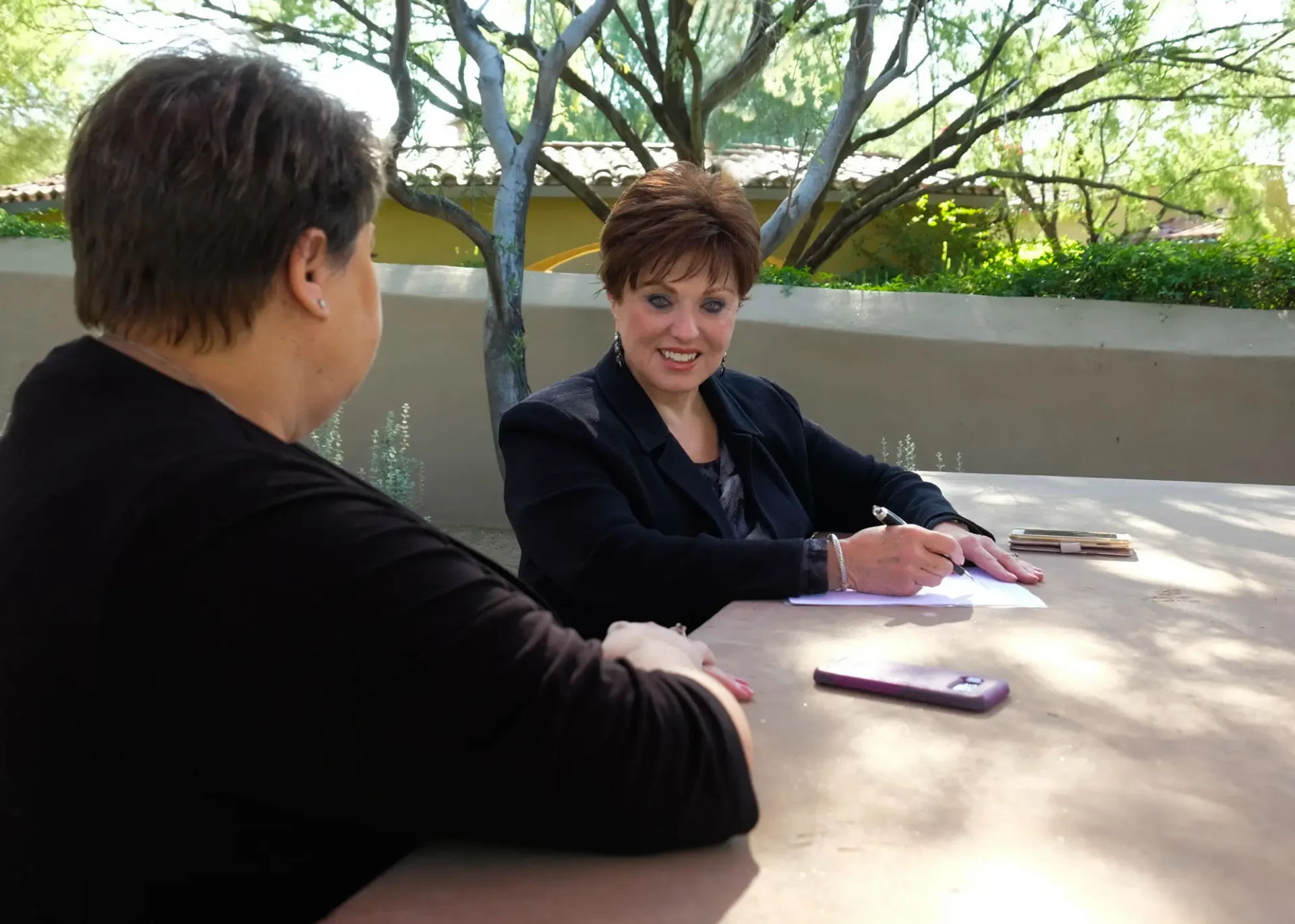 A woman sitting at a table with another person.